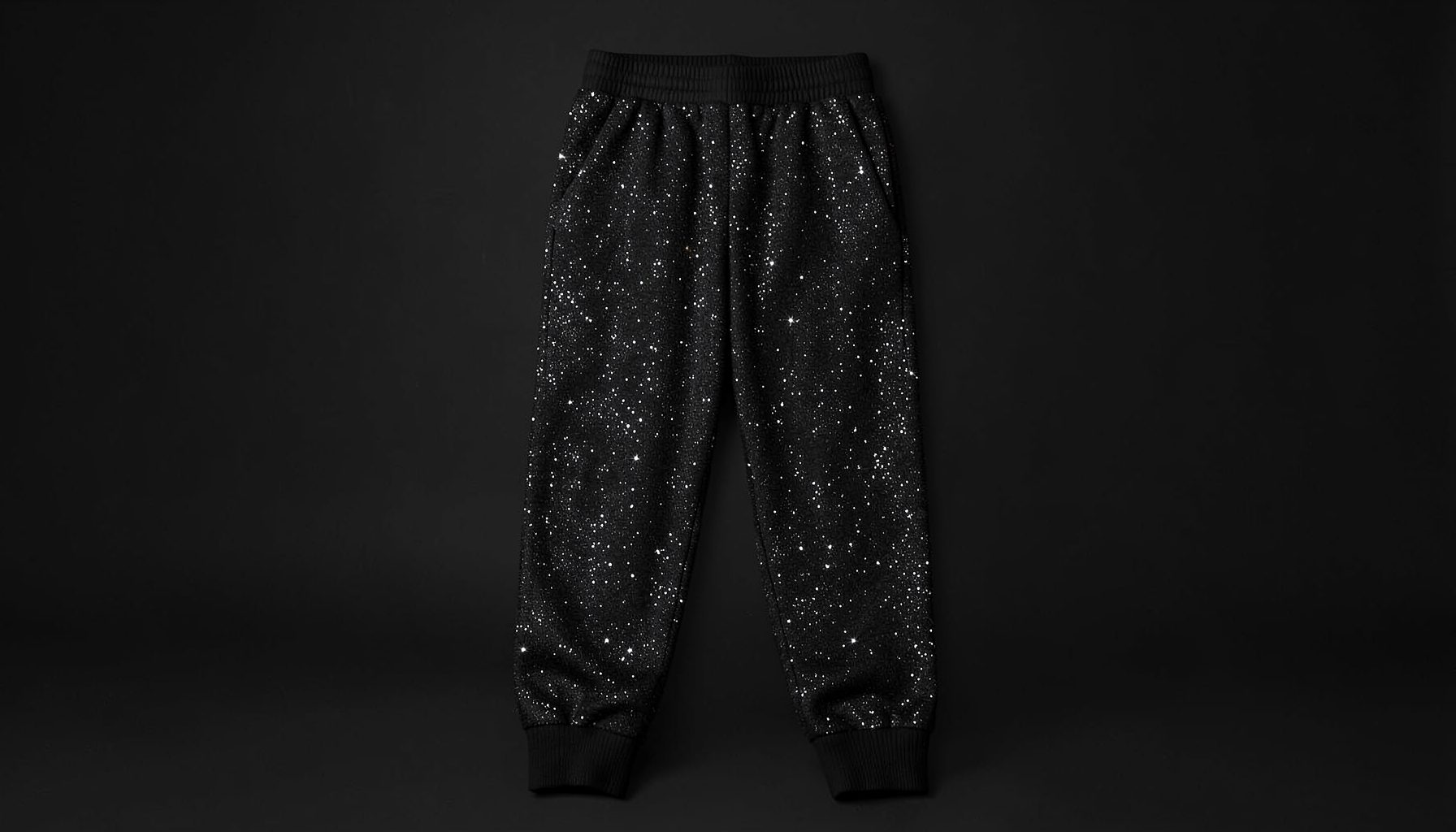Black diamante graphic joggers with sparkle detailing, relaxed fit, styled on a dark background