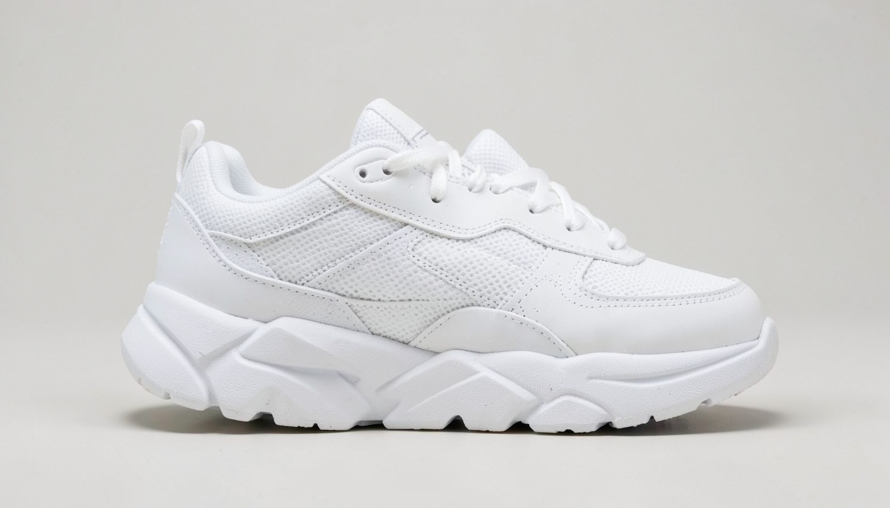 White chunky panelled sneakers with a sporty silhouette, crisp against a neutral background
