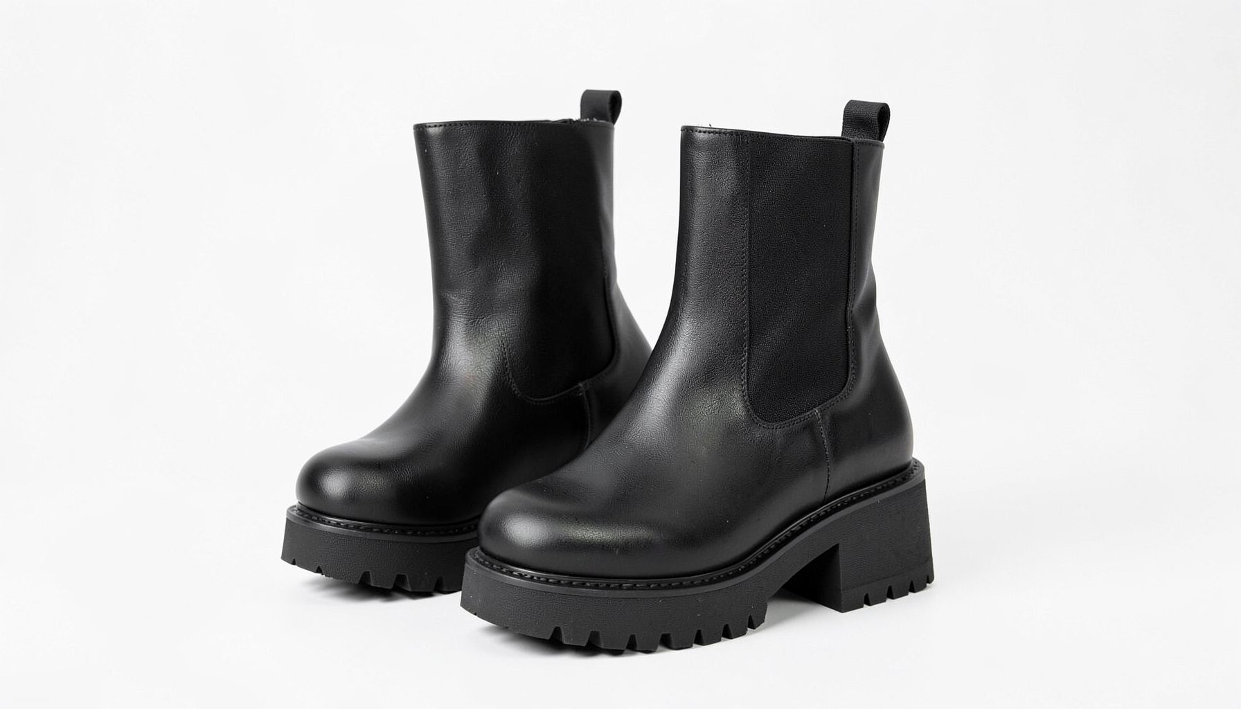 Wide-fit chunky heeled Chelsea boots in black with elastic side panels and a sturdy sole on a clean white backdrop